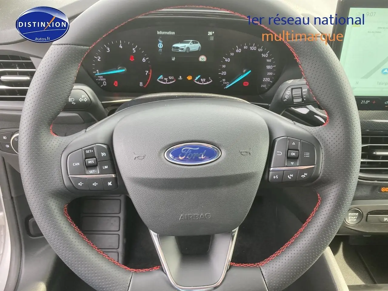 Volant perforé avec coutures rouges et tableau de bord numérique de la Ford Focus gris 2025 vue de face intérieure.