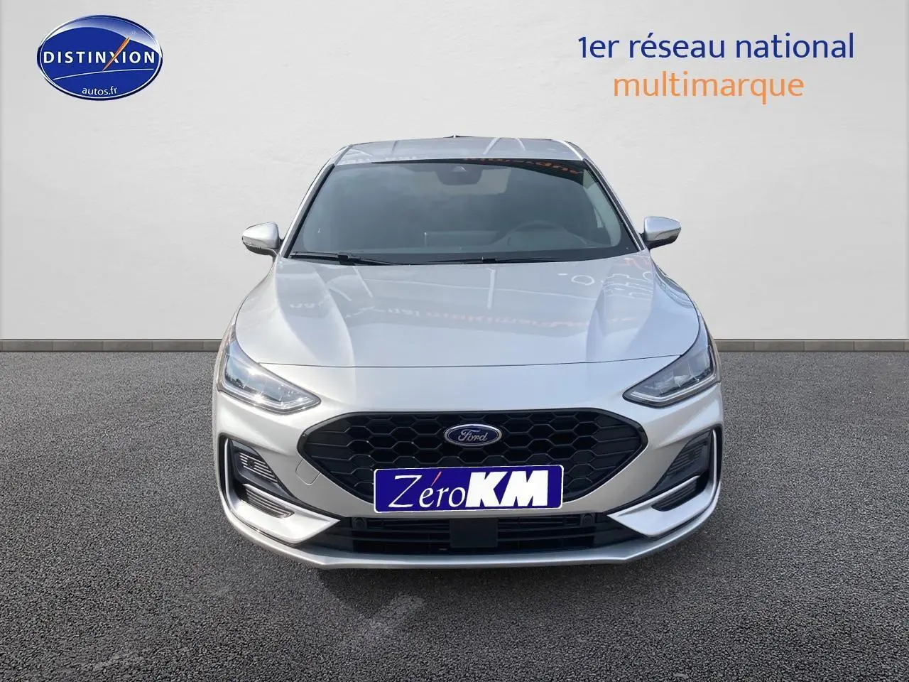 Vue frontale d'une Ford Focus gris clair avec calandre noire et feux LED modernes sur fond neutre.