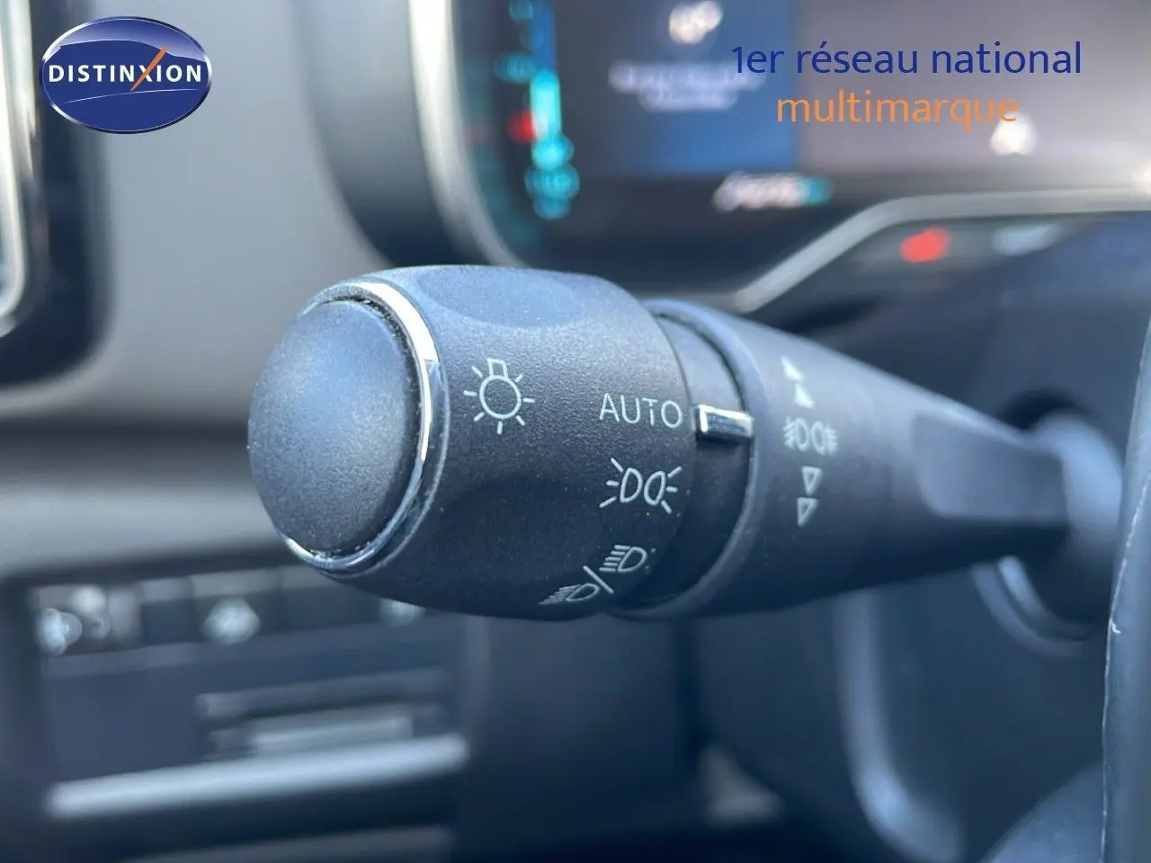 Gros plan sur la commande des phares du Citroën C5 Aircross blanc nacré hybride, intérieur noir moderne.