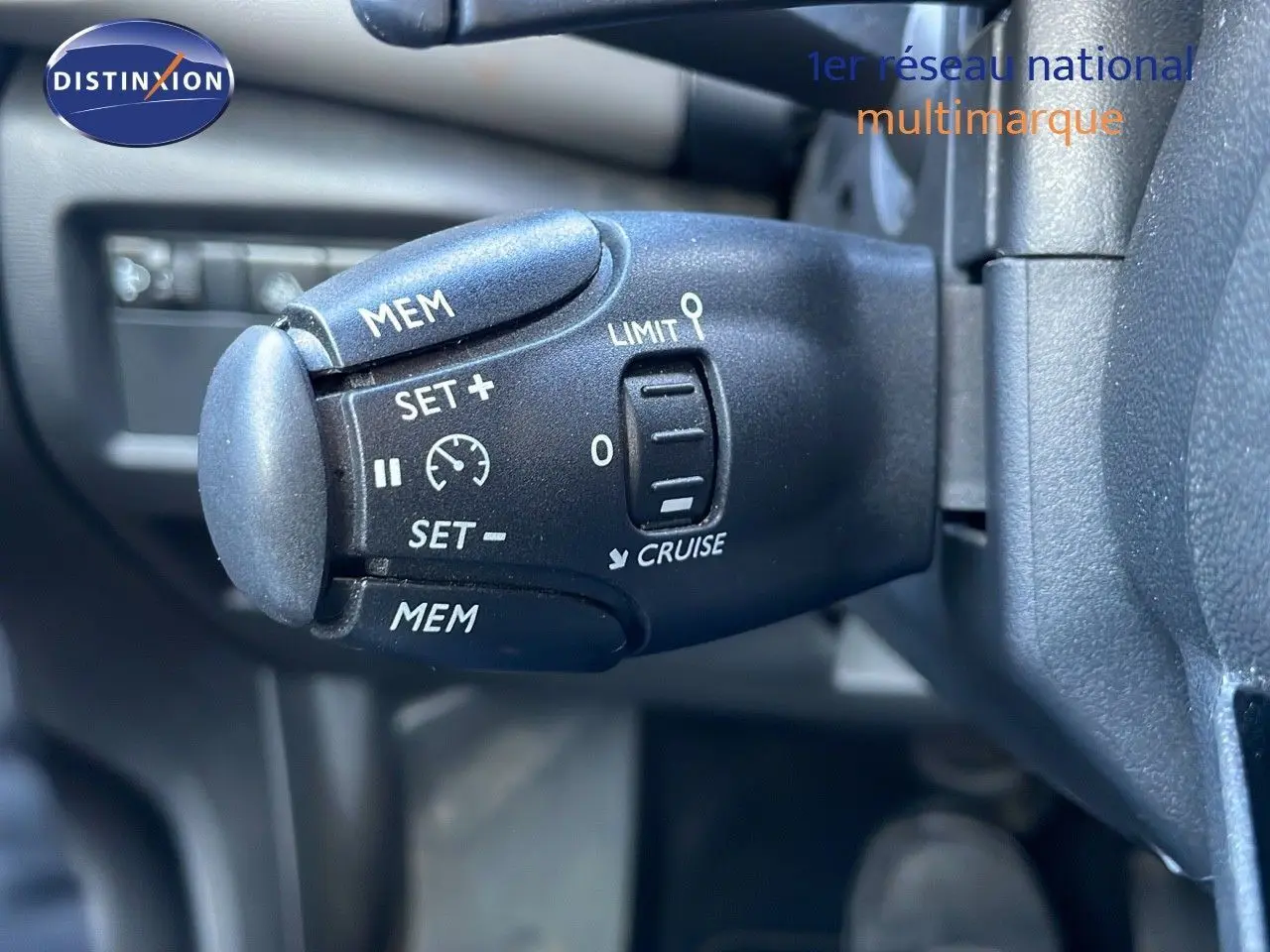 Gros plan sur la commande de régulateur de vitesse du Citroën C5 Aircross hybride, intérieur noir.