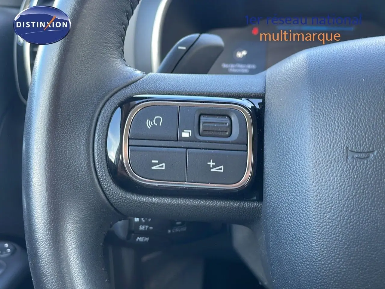 Gros plan sur les commandes gauche du volant noir du Citroën C5 Aircross blanc nacré hybride 2021.