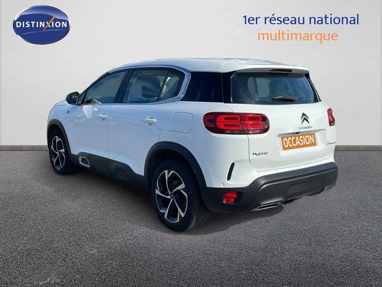 Vue 3/4 arrière droite d'un Citroën C5 Aircross blanc nacré hybride avec jantes bi-ton et toit noir.