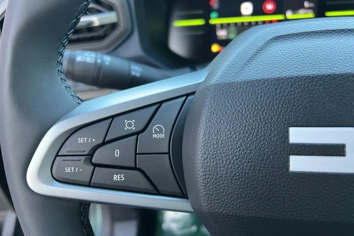 Gros plan sur les commandes au volant à gauche du Dacia Duster 2025, version Mild Hybrid 130 4x4 Expression.