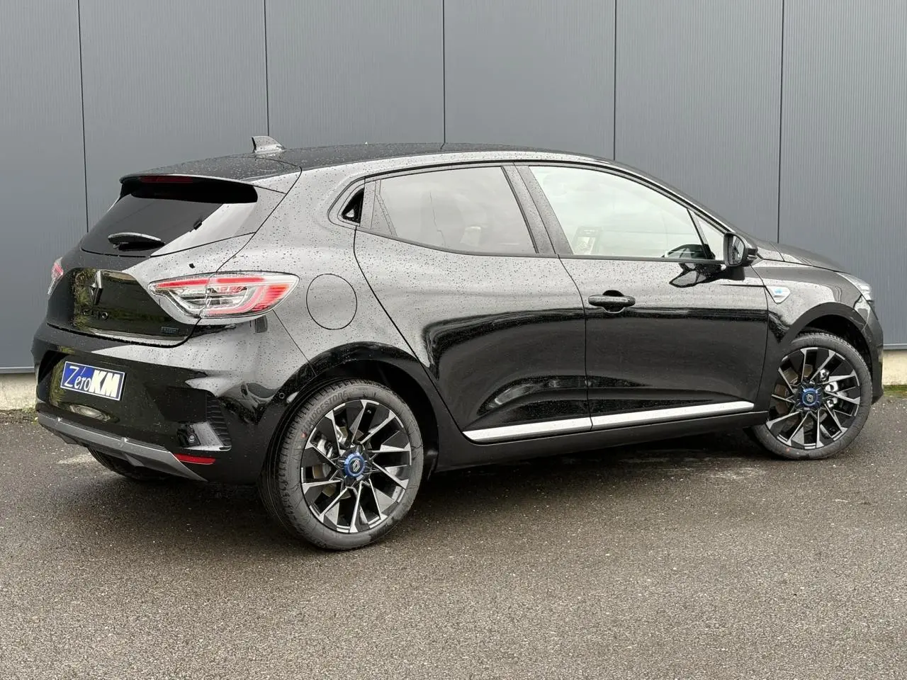 Vue 3/4 arrière côté droit d'une Renault Clio noire étoile avec jantes alliage et vitres surteintées.