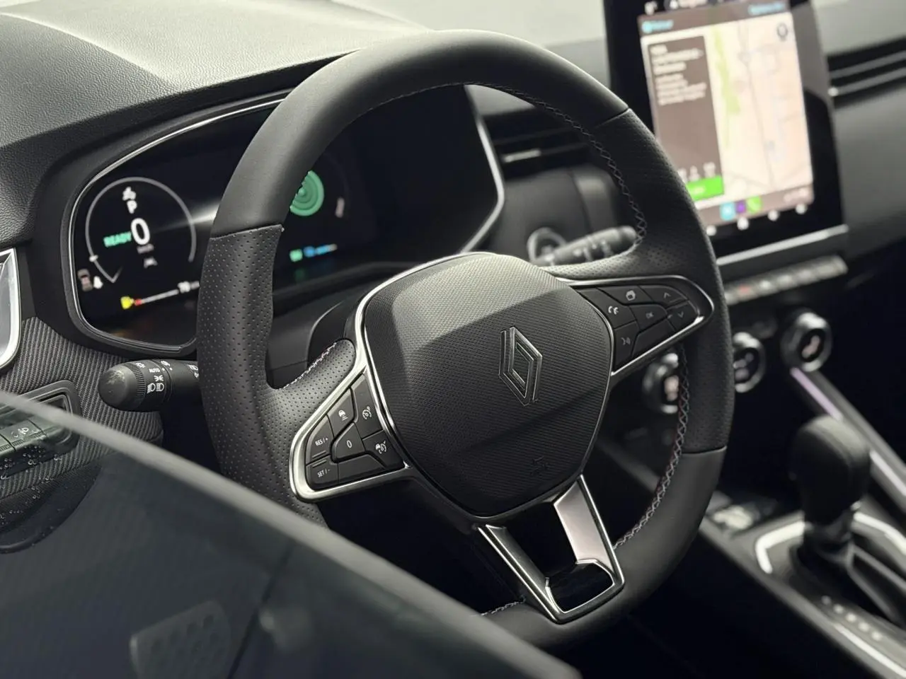 Vue rapprochée du volant multifonction noir de la Renault Clio V NV E-Tech 2025 avec tableau de bord numérique et écran tactile.