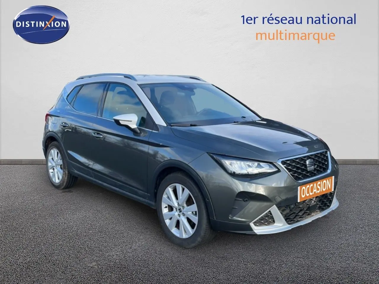 SEAT Arona gris falaise métal avec toit blanc, vue 3/4 avant droit, calandre et jantes visibles, plaque occasion orange.