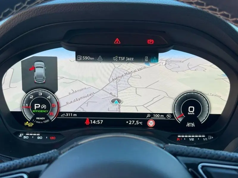 Vue rapprochée du tableau de bord numérique de l'Audi Q2 35 TDI 150ch S line, affichant la navigation et les indicateurs de conduite.