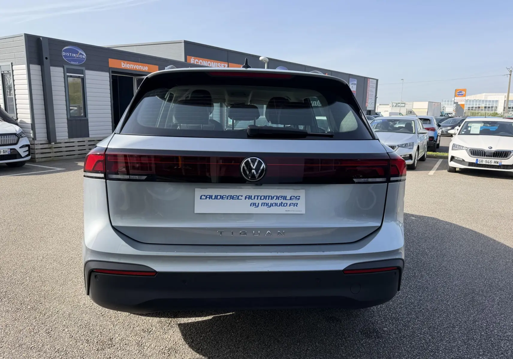 Vue arrière d’un Volkswagen Tiguan gris 2025 avec feux arrière LED traversants et logo VW centré.