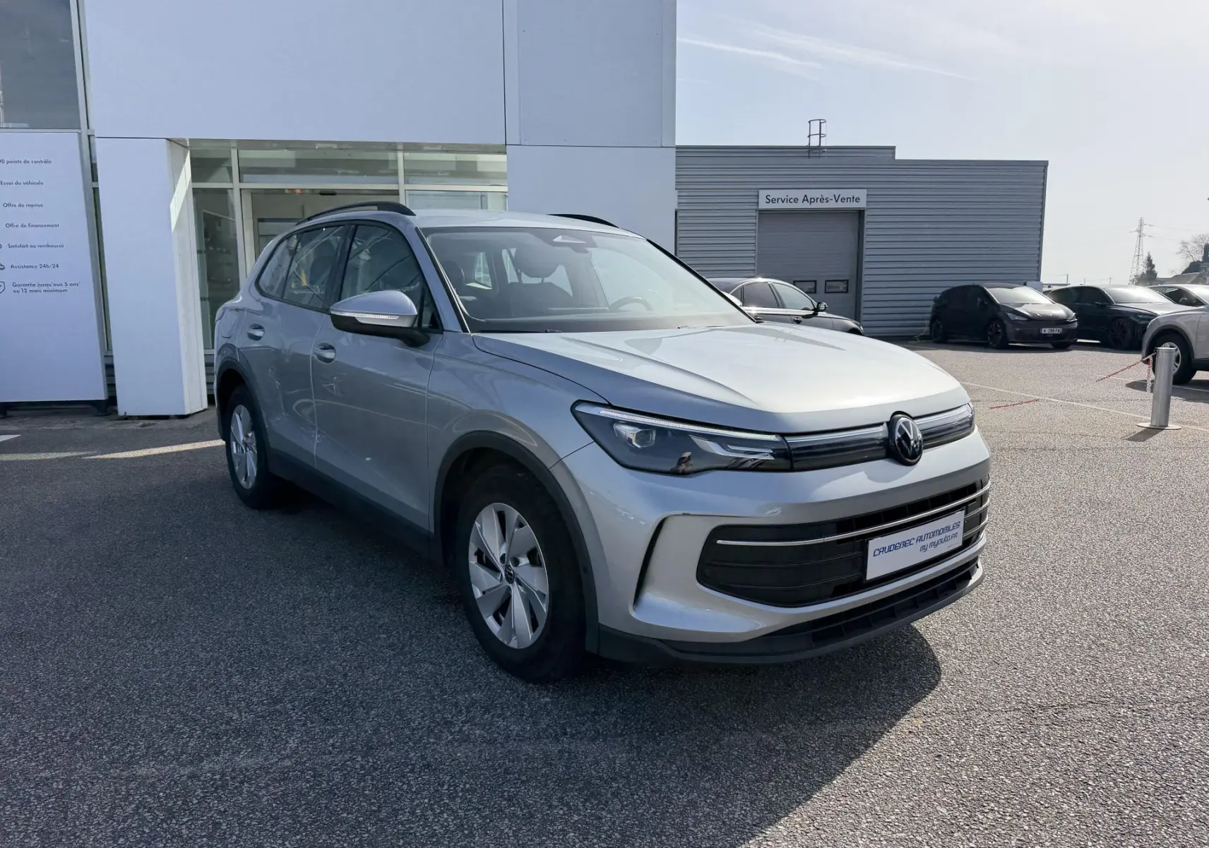 Volkswagen Tiguan gris en 3/4 avant droit, avec calandre noire et jantes alliage 17 pouces visibles.