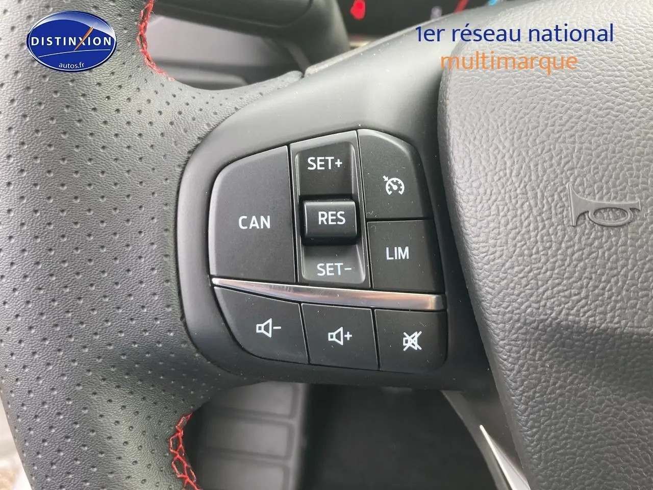 Gros plan sur le volant perforé noir avec coutures rouges et commandes de régulateur de vitesse de la Ford Focus 2025.