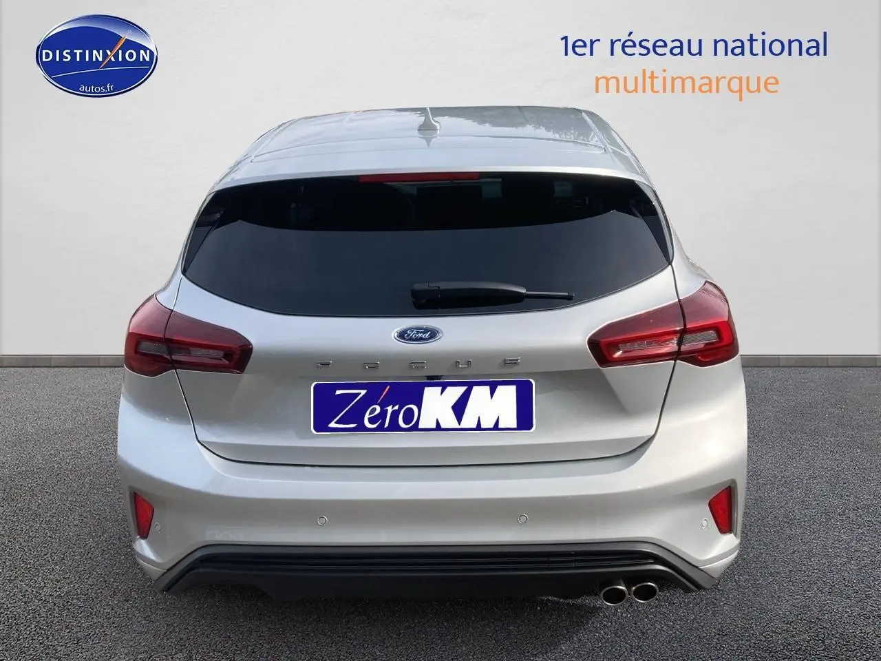 Vue arrière d'une Ford Focus gris clair 2025 avec double pot d'échappement et vitres arrière surteintées.