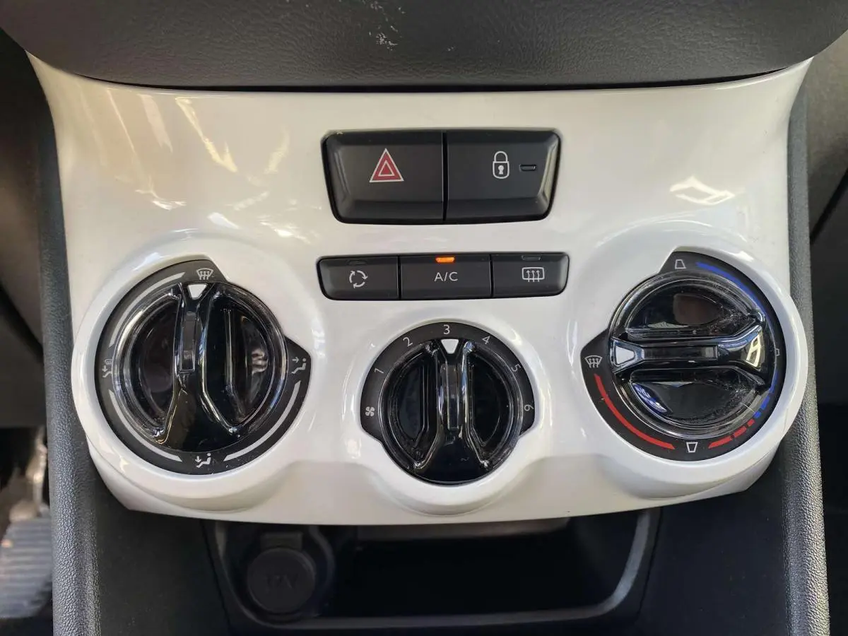 Commandes de climatisation blanches et noires du tableau de bord du Peugeot 208 2015 version Like essence.