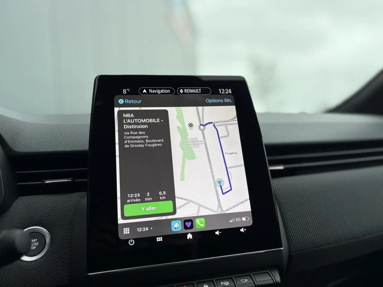 Écran tactile central du tableau de bord de la Renault Clio Gris Rafale affichant la navigation GPS en mode hybride.