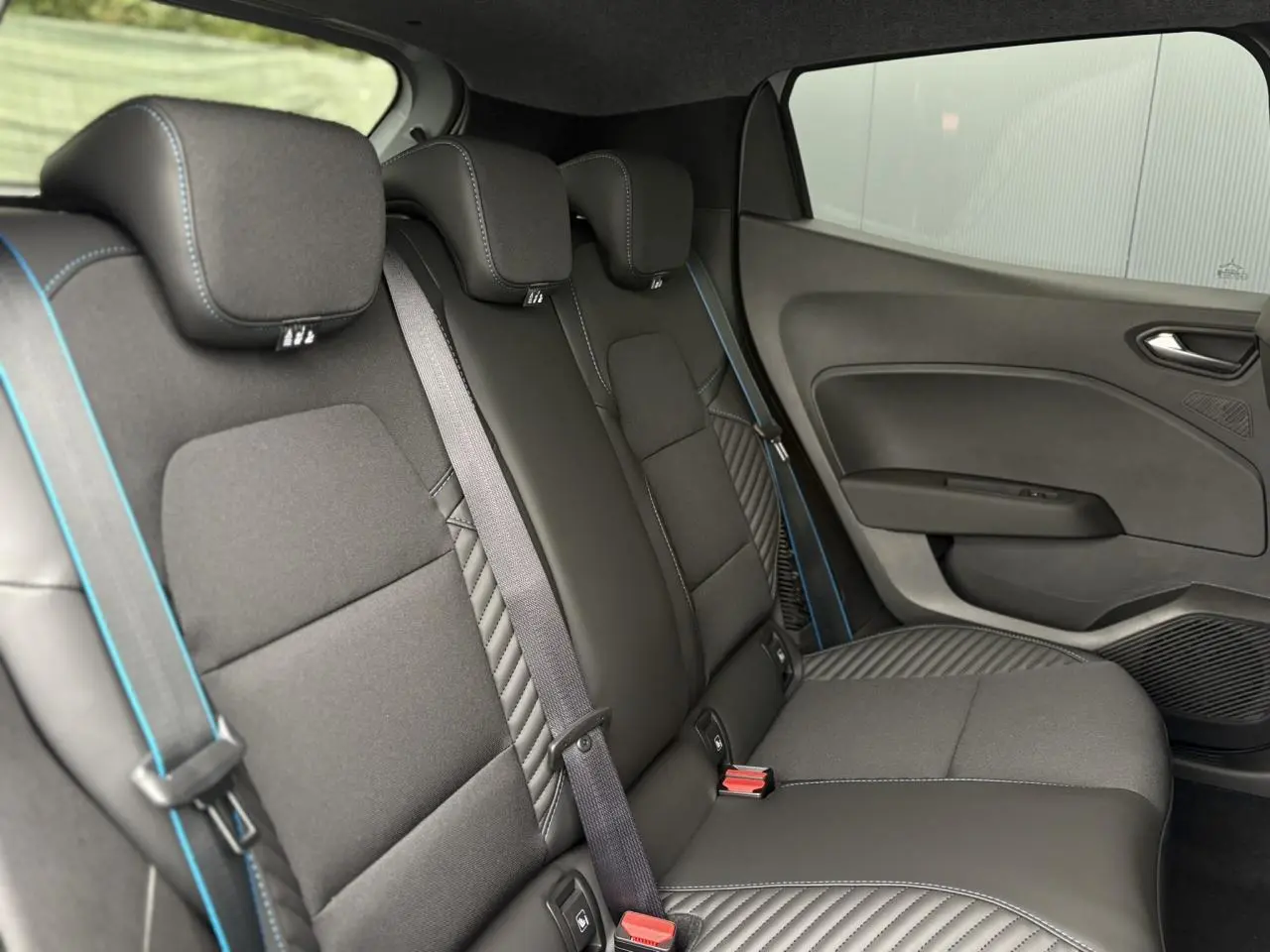 Vue intérieure côté droit des sièges arrière noirs avec surpiqûres bleues de la Renault Clio Esprit Alpine 2025.