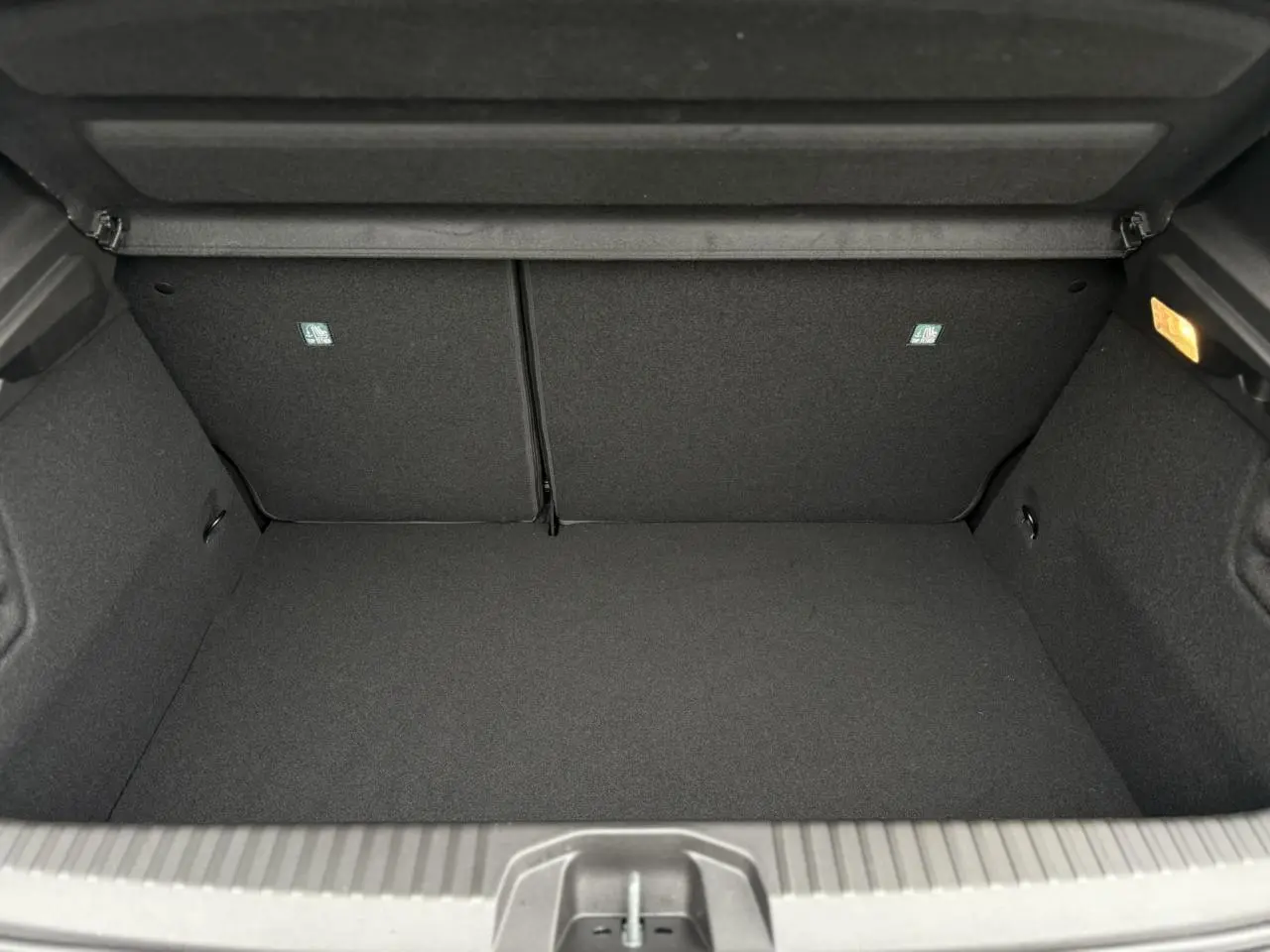 Coffre ouvert noir de la Renault Clio V NV E-Tech Full Hybrid 2025, montrant un espace de rangement propre et éclairé.