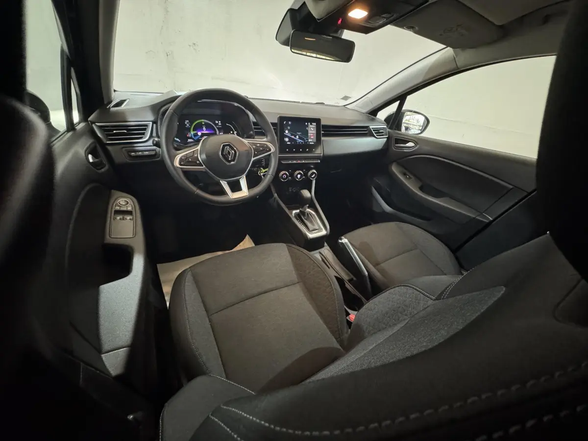 Vue intérieure avant droite de la Renault Clio Business E-Tech hybride 2021 avec sièges noirs et tableau de bord numérique.