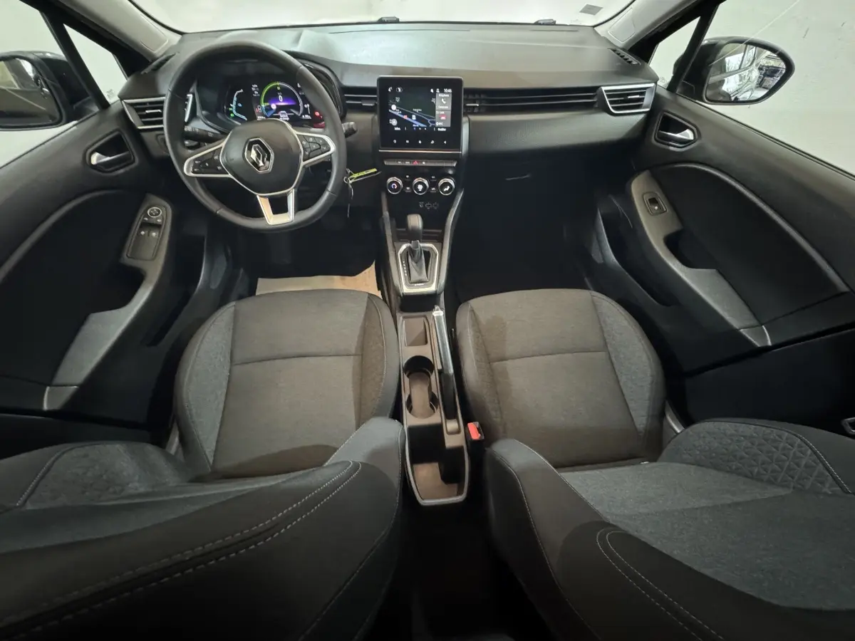 Vue intérieure avant de la Renault Clio Business E-Tech hybride 2021, tableau de bord noir avec écran tactile central et volant multifonctions.