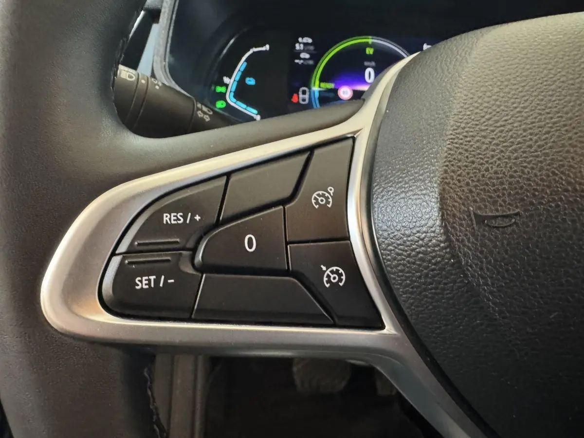 Gros plan sur les commandes de régulateur de vitesse au volant cuir d’une Renault Clio Business E-Tech hybride 2021.
