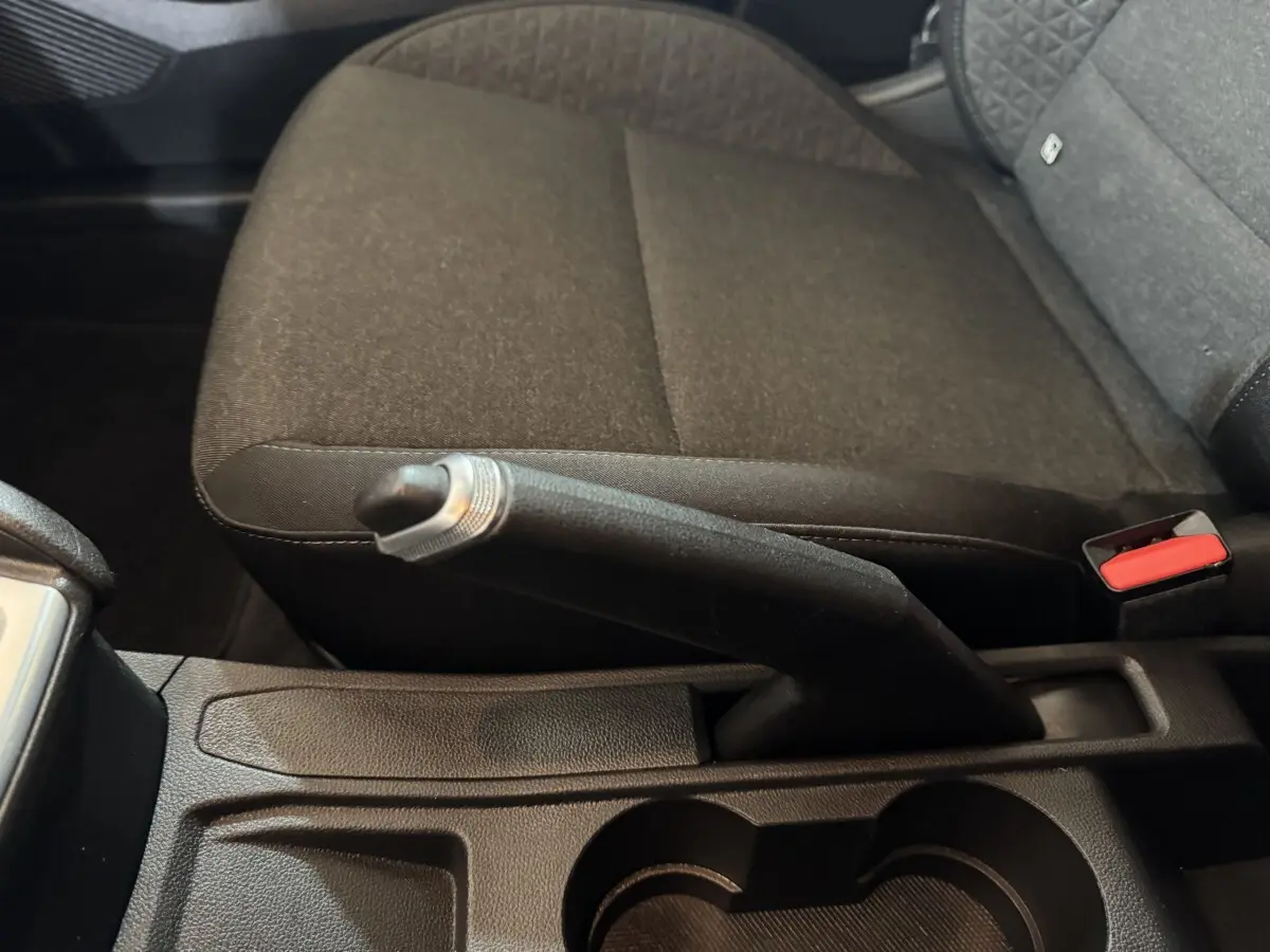 Vue rapprochée de la console centrale intérieure de la Renault Clio Business E-Tech hybride 2021, montrant le frein à main manuel et la banquette arrière noire.