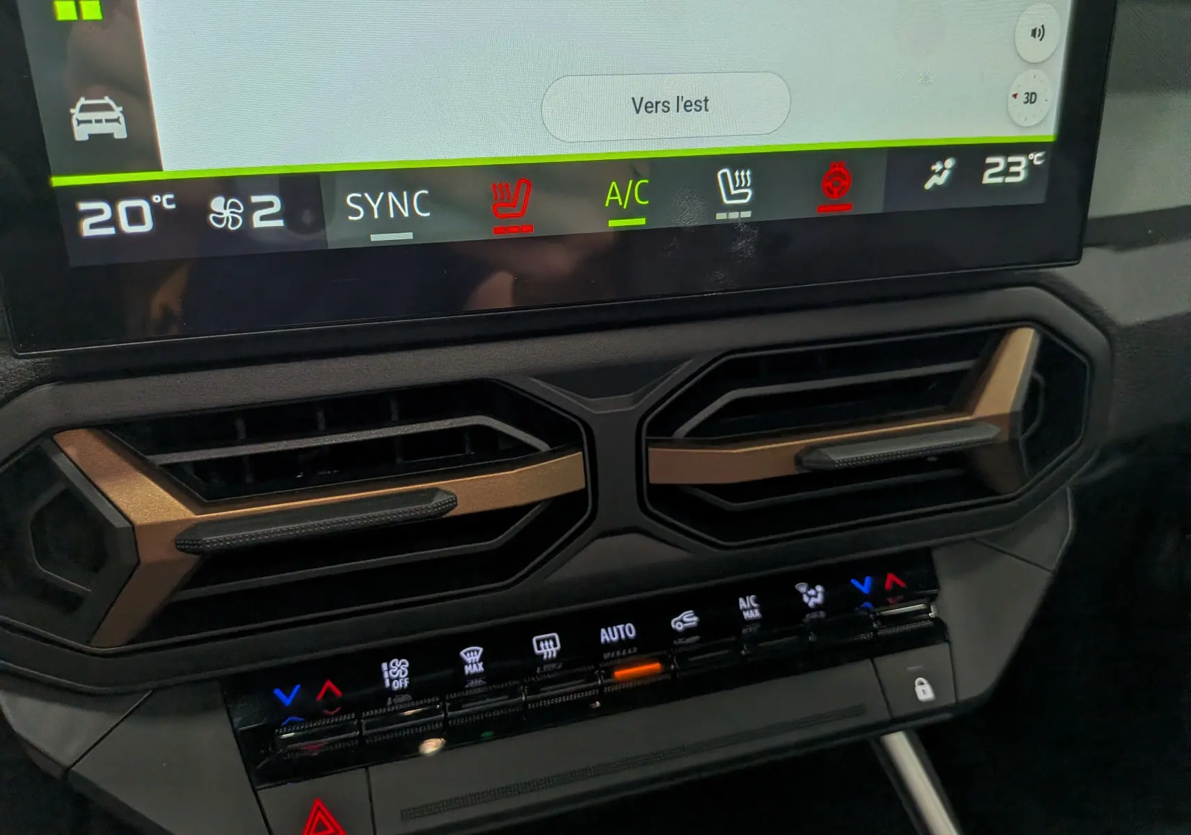 Gros plan sur la console centrale du Dacia Bigster Hybrid-G 150 avec écran tactile et commandes de climatisation.