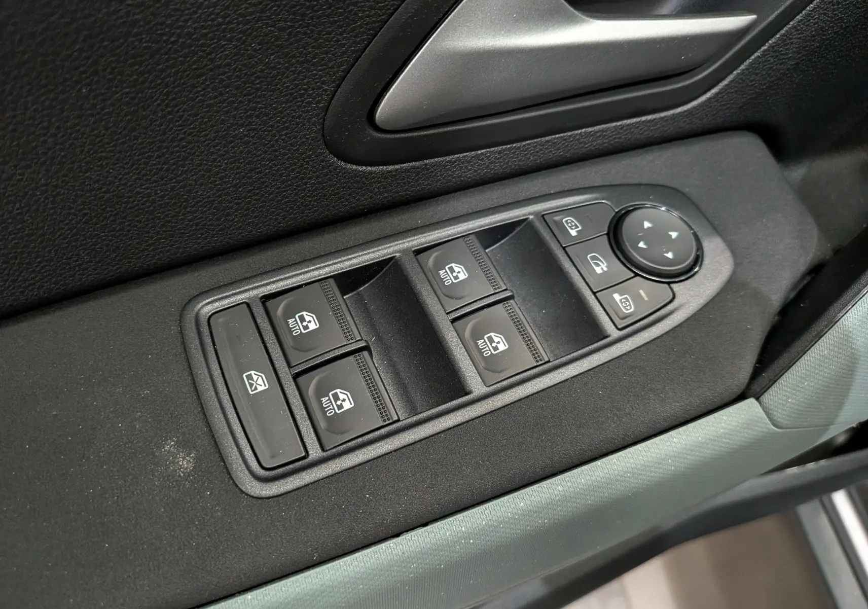 Commande des vitres et rétroviseurs sur la porte côté gauche du Dacia Bigster Hybrid-G 150 4x4 gris schiste, intérieur noir.
