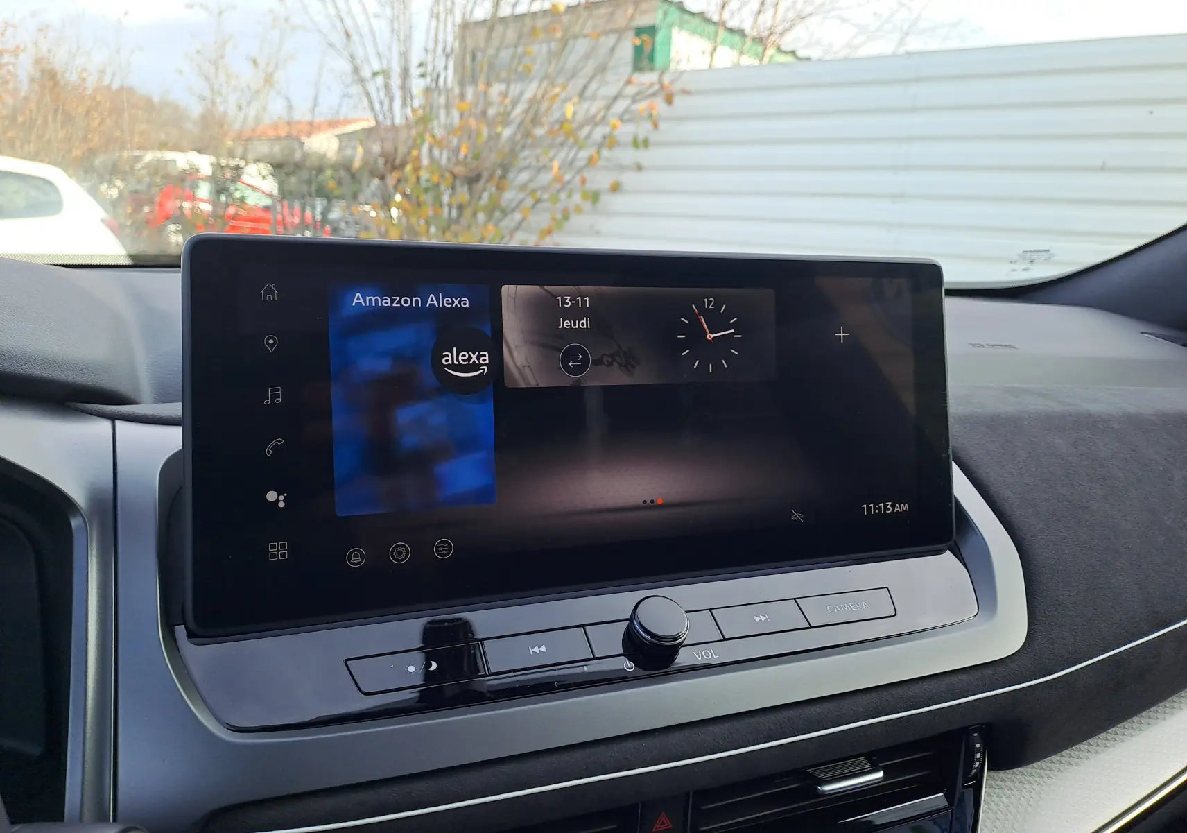 Écran tactile central du Nissan Qashqai 2025 affichant Amazon Alexa, avec tableau de bord noir et gris.