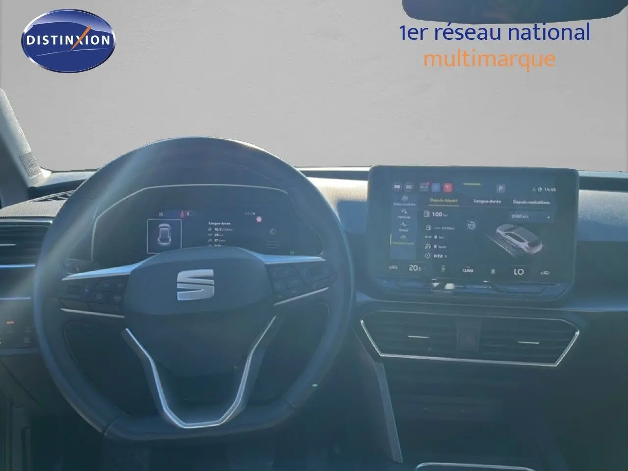 Vue intérieure centrée sur le volant et l’écran tactile du tableau de bord d’une SEAT LEON gris magnétique 2025.