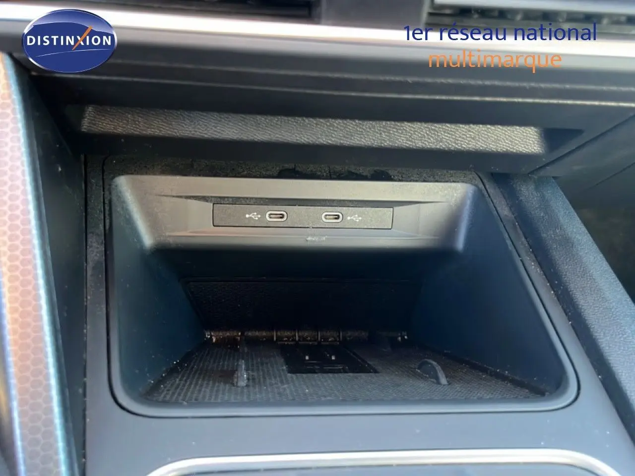 Gros plan sur la console centrale intérieure du SEAT Leon 2025, montrant deux ports USB-C dans un espace de rangement noir.