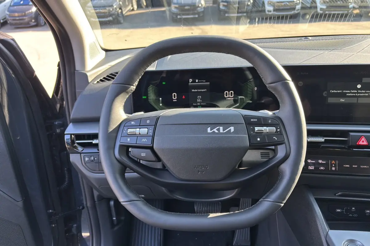 Vue intérieure centrée sur le volant cuir multifonctions du Kia Sportage 2026, avec tableau de bord digital.