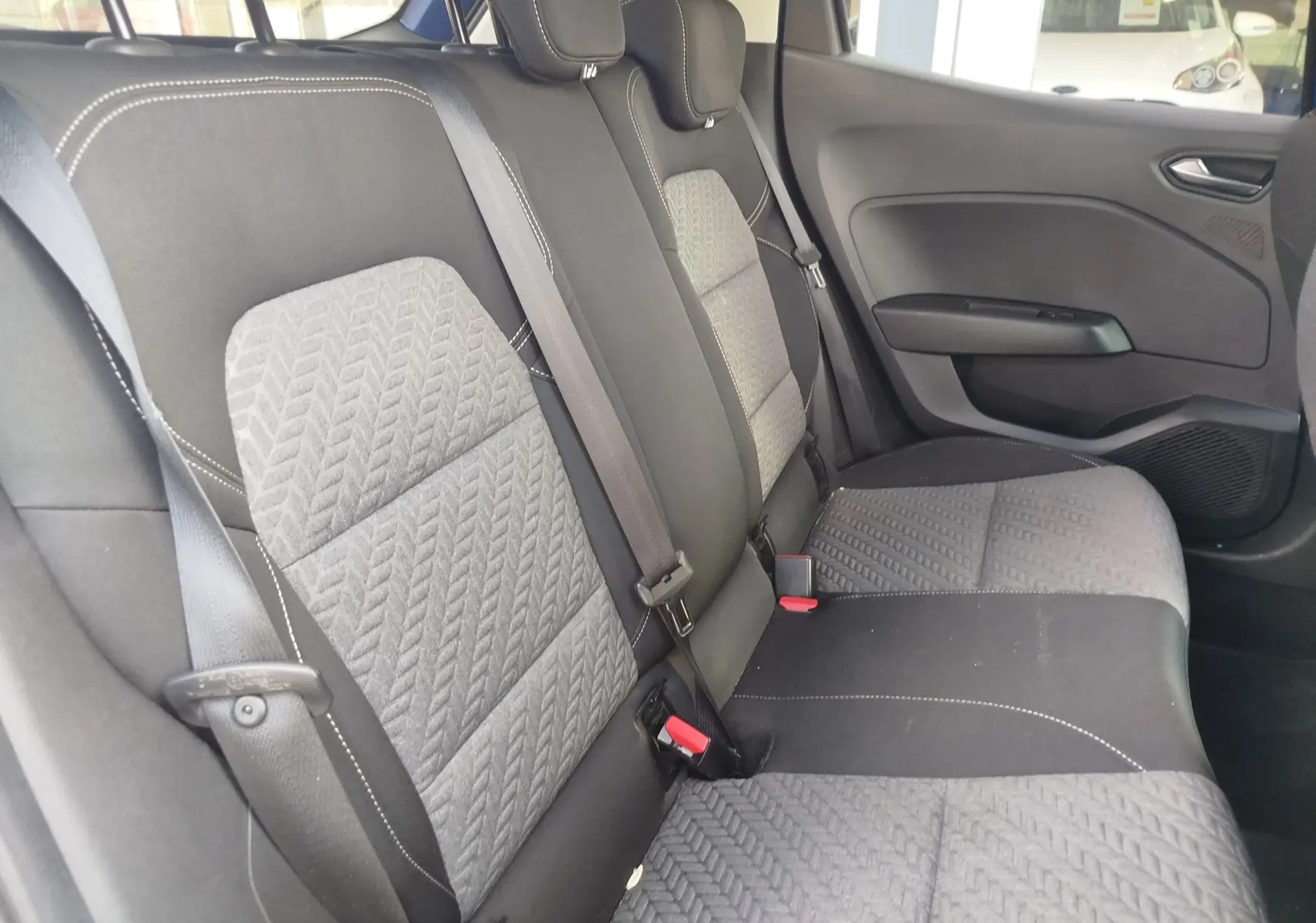 Vue intérieure côté droit des sièges arrière gris et noirs avec ceintures dans une Renault Clio 2022.