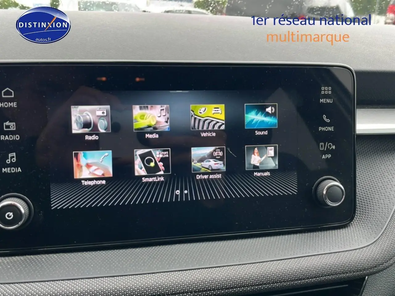Écran tactile central affichant le menu multimédia dans l'habitacle d'une Skoda Fabia blanche, vue de face.