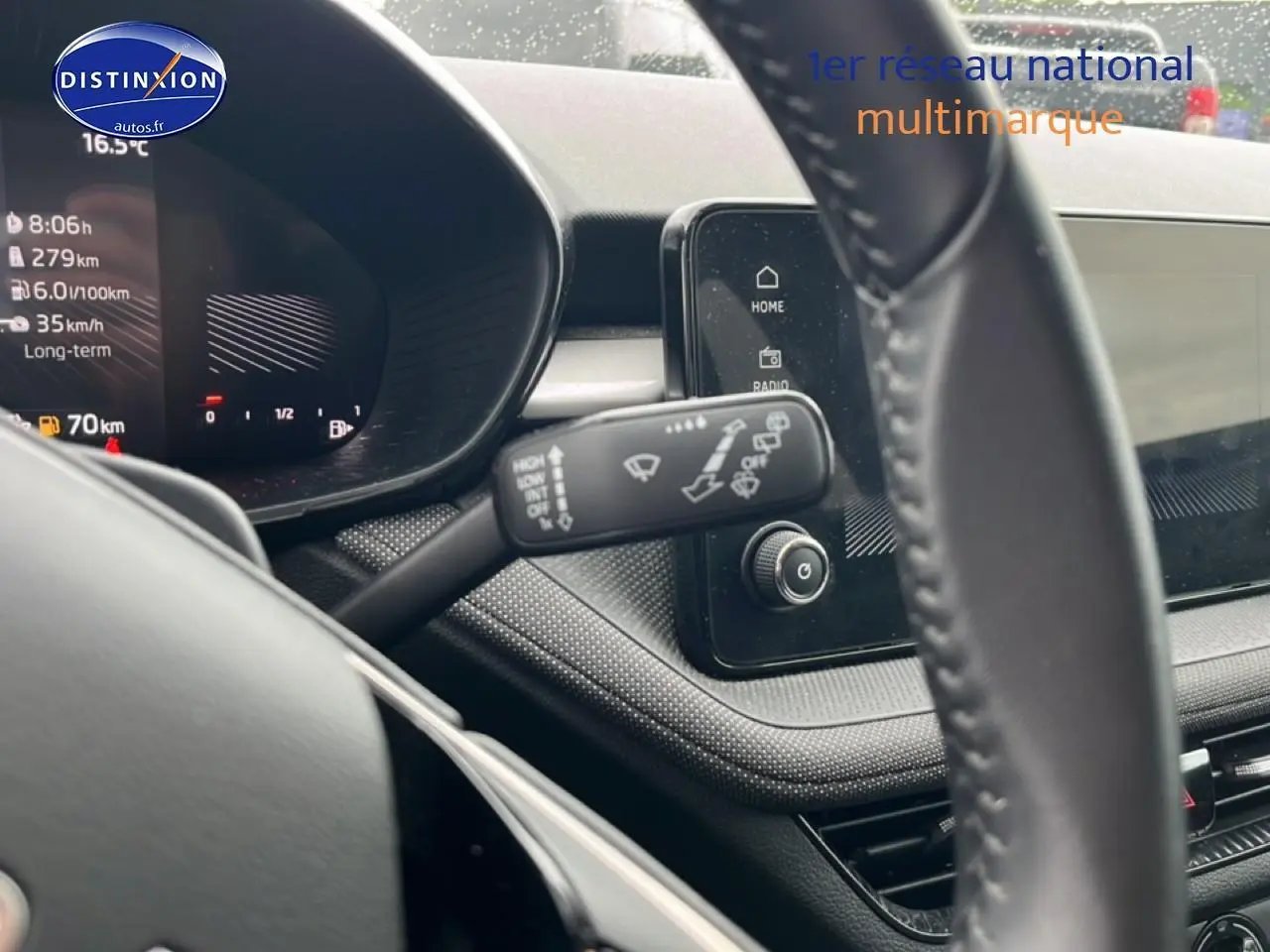 Vue intérieure rapprochée du tableau de bord et volant cuir noir de la Skoda Fabia blanche 2025.