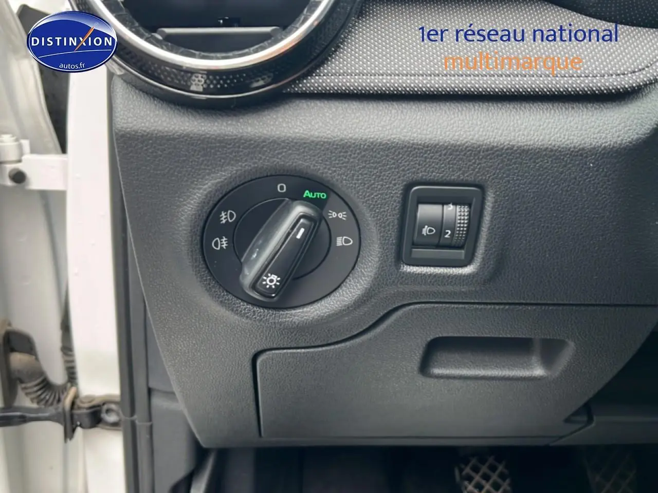 Détail du tableau de bord côté gauche d’une Skoda Fabia blanche 2025, avec commandes d’éclairage et réglage phares.