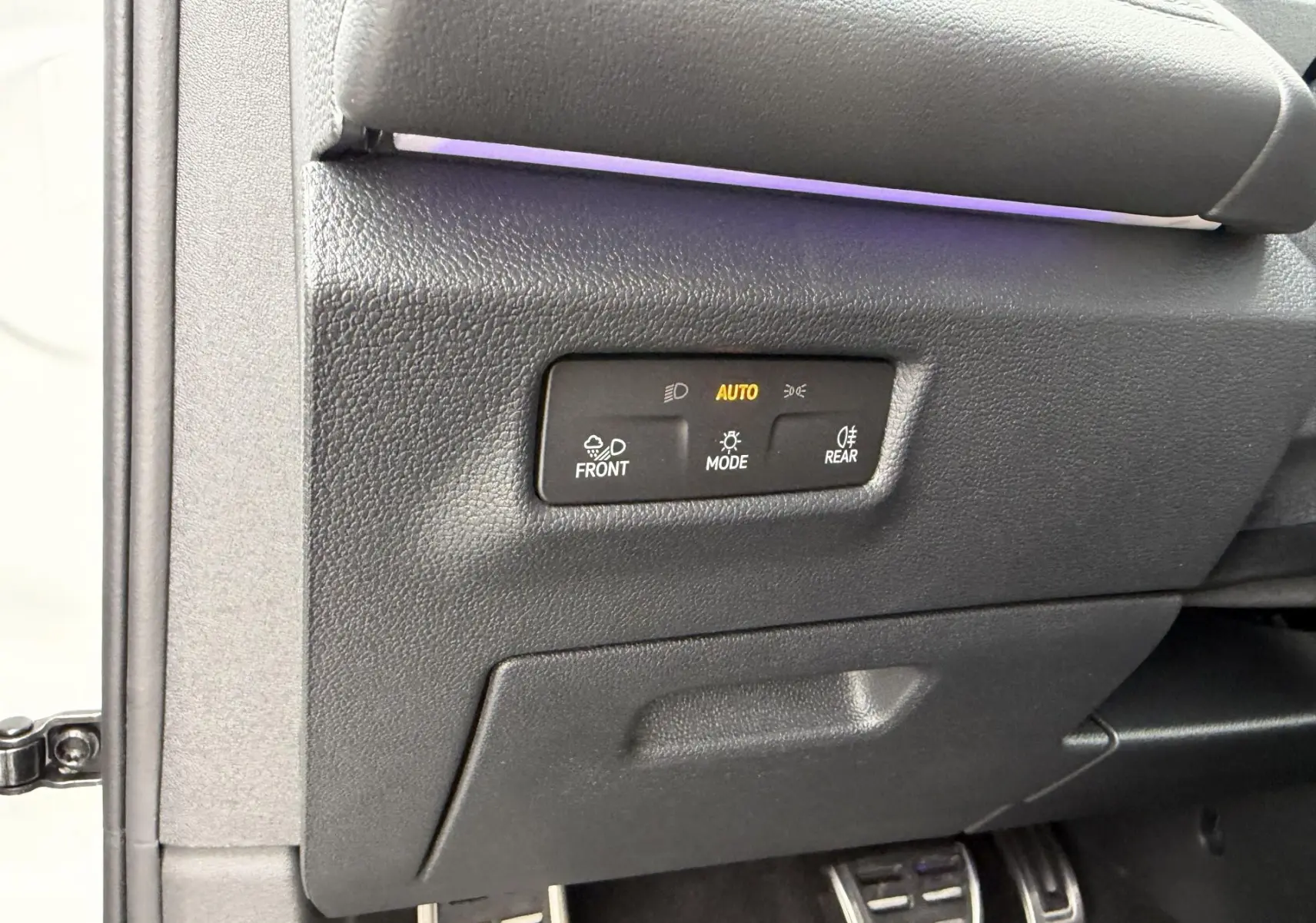 Détail intérieur côté gauche du tableau de bord du Volkswagen Tiguan blanc avec commandes d’éclairage automatiques.
