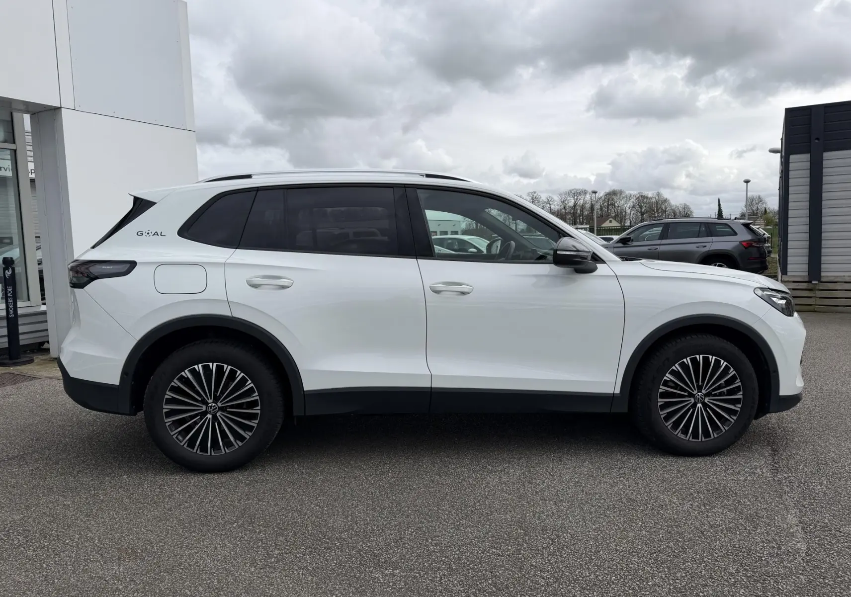 Profil droit du Volkswagen Tiguan blanc 2025 avec vitres arrière teintées et jantes alliage noires.