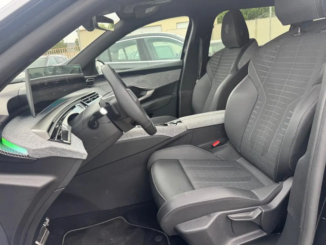 Vue intérieure côté conducteur du Peugeot 5008 Hybrid 145 ch e-DCS6 GT 2025, sièges noirs et tableau de bord numérique.