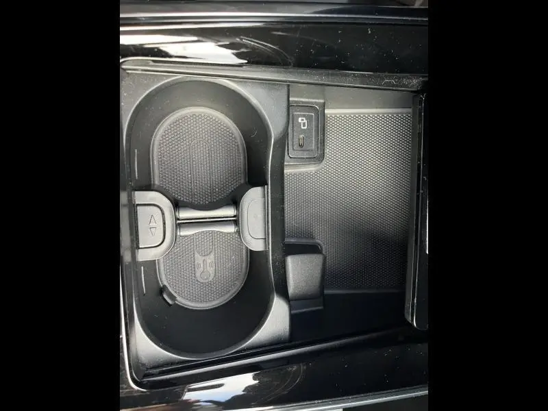 Gros plan sur le porte-gobelets noir et prise USB dans la console centrale d'une Mercedes GLA 200 rouge Patagonie métallisé designo