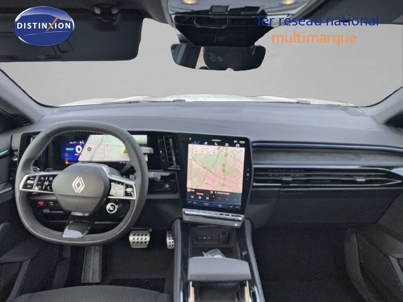 Vue intérieure avant du Renault Austral blanc nacré, tableau de bord moderne avec écran tactile central affichant une carte.