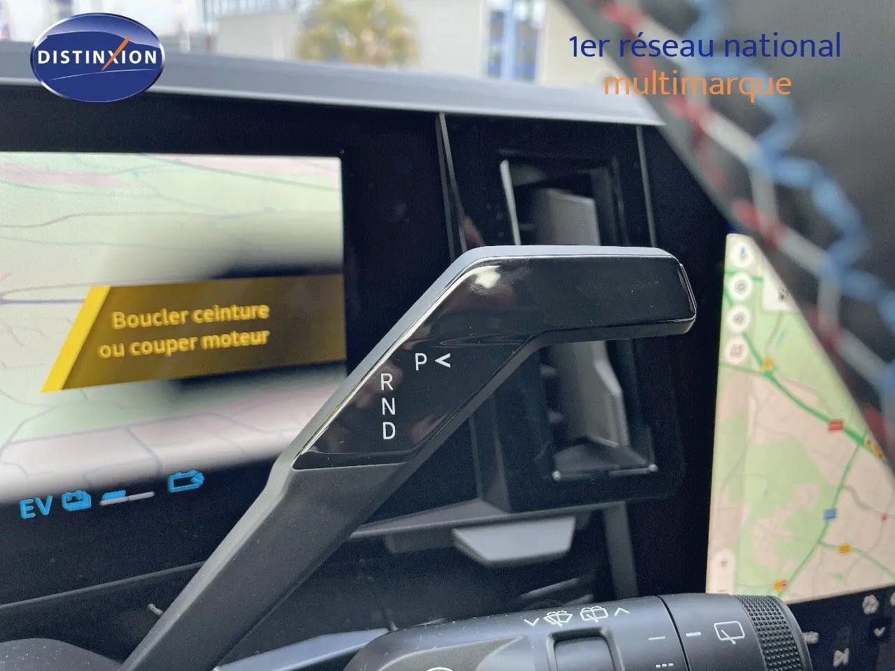 Le levier de vitesses automatique noir du Renault Austral E-Tech, avec écran tactile affichant la navigation en arrière-plan.