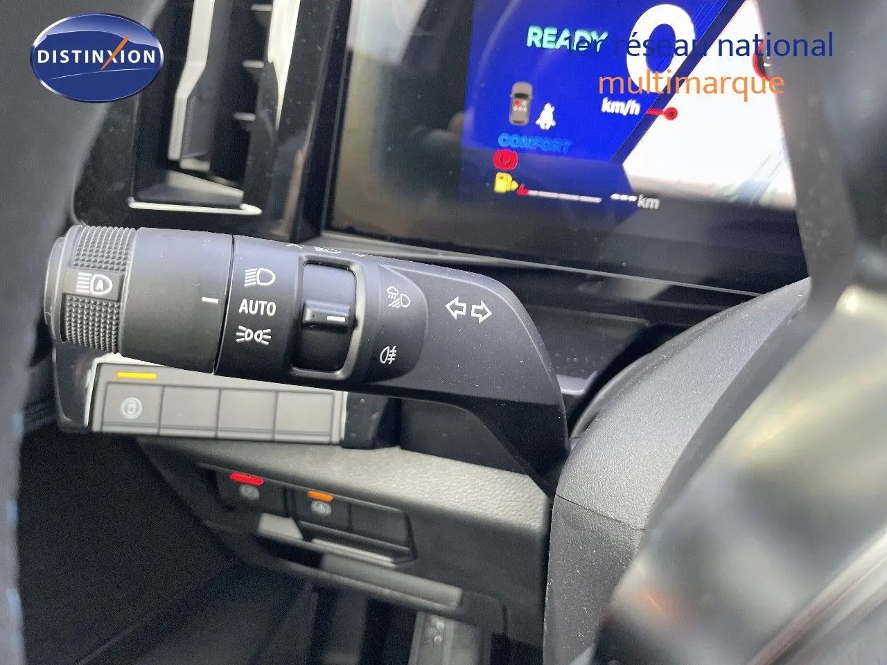 Gros plan sur la commande des phares et clignotants à gauche du volant du Renault Austral blanc nacré 2025.