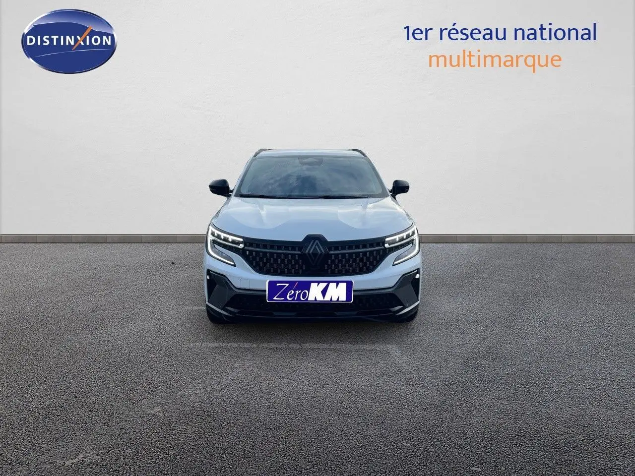 Vue de face du Renault Austral blanc nacré avec calandre noire et phares LED allumés sur fond neutre.