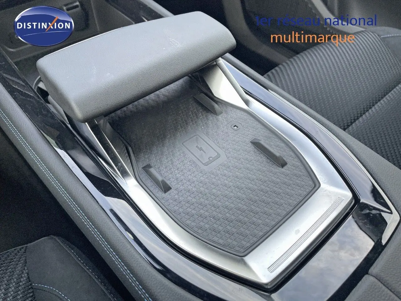 Plateau de recharge sans fil et accoudoir central dans l'habitacle du Renault Austral E-Tech blanc nacré 2025.