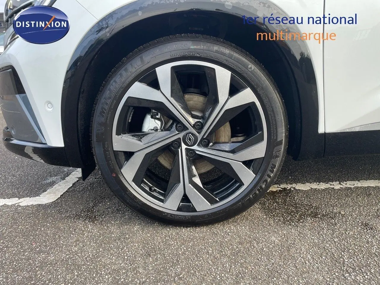 Gros plan sur la roue avant gauche du Renault Austral blanc nacré, mettant en valeur la jante alliage au design moderne.