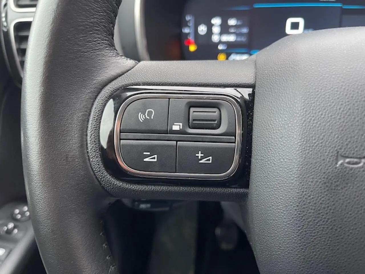 Gros plan sur les commandes au volant gauche du Citroën C5 Aircross 2021, avec boutons de volume et téléphone.
