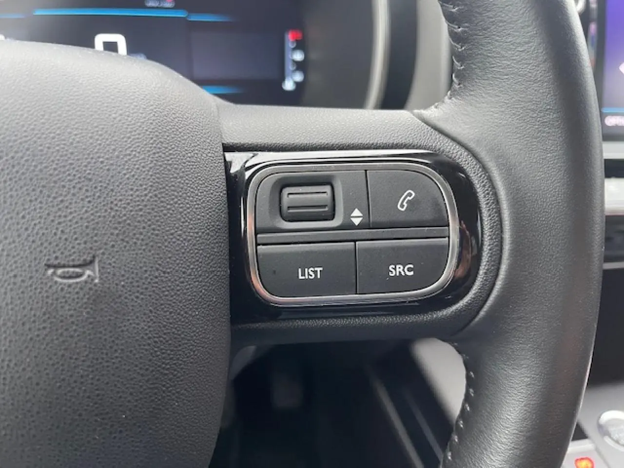 Gros plan sur les commandes au volant à droite du Citroën C5 Aircross 2021, cuir noir avec boutons de téléphone et menu.