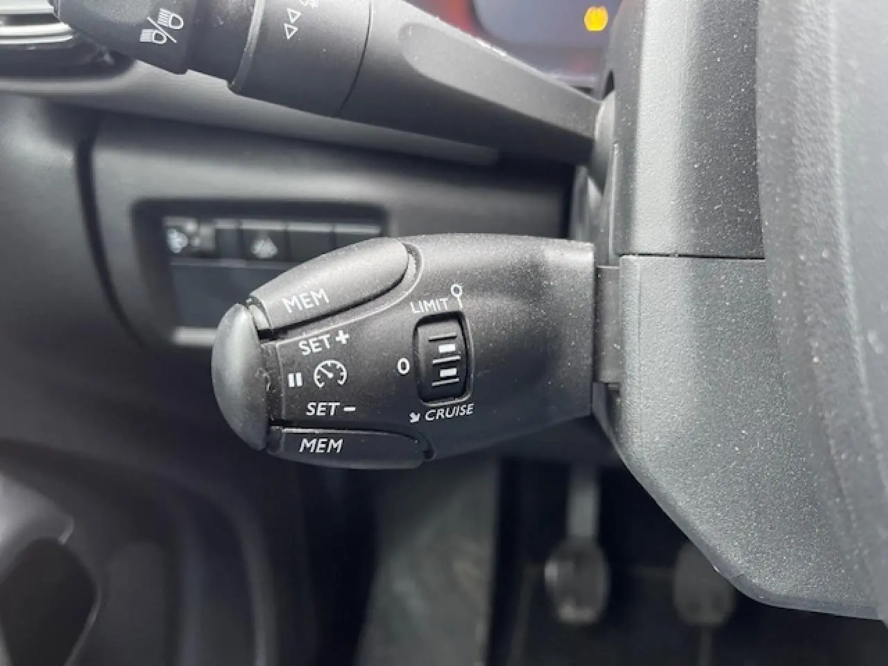 Gros plan sur la commande de régulateur de vitesse du Citroën C5 Aircross 2021, finition Feel Pack, intérieur noir.