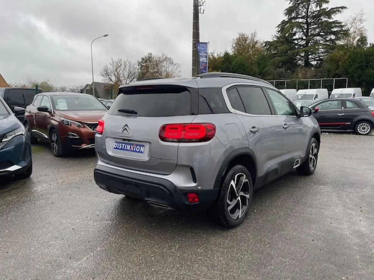 Vue 3/4 arrière droite d'un Citroën C5 Aircross gris Artense avec feux arrière LED et jantes alliage 18 pouces Swirl.