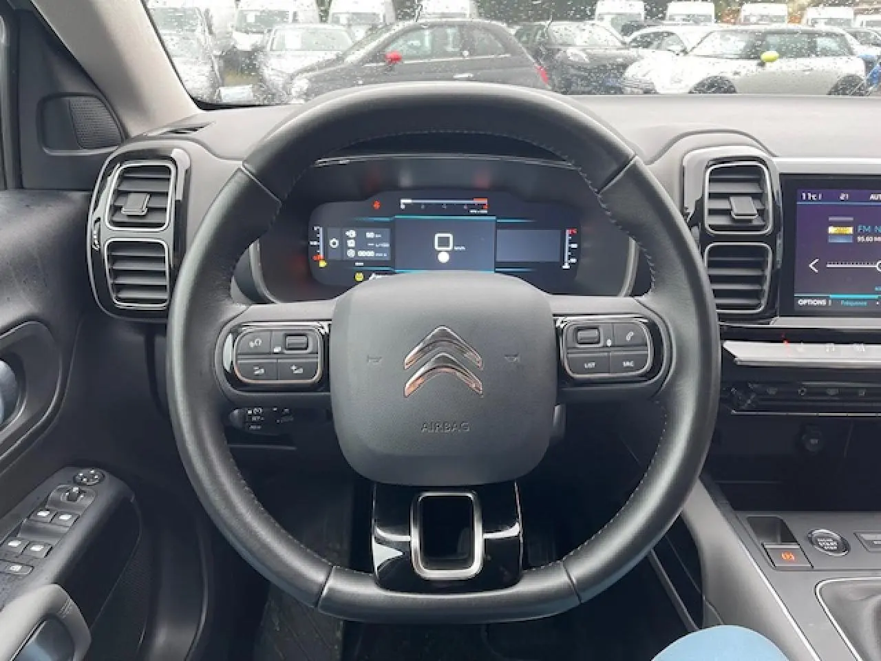 Vue centrée sur le volant et tableau de bord du Citroën C5 Aircross 2021, intérieur moderne noir avec écran tactile.