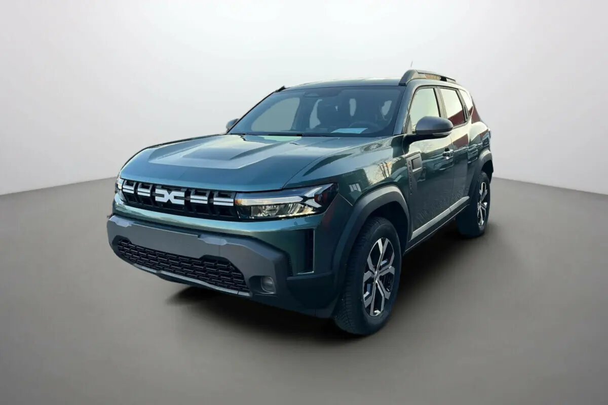 Dacia Duster 2025 vert cèdre en 3/4 avant droit, avec calandre distinctive et jantes alliage noires et argentées.