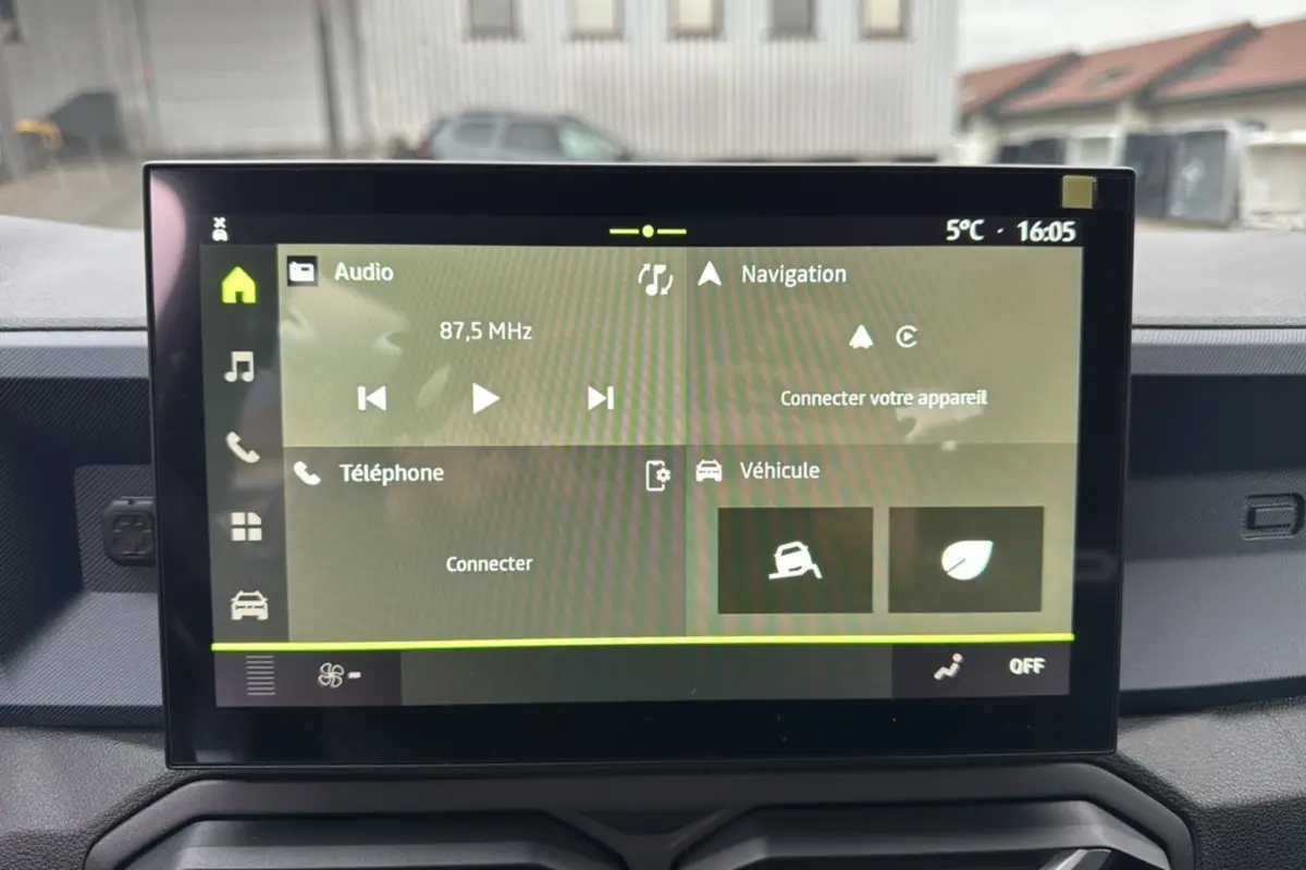 Écran tactile du tableau de bord du Dacia Duster 2025 affichant les menus audio, navigation et véhicule.